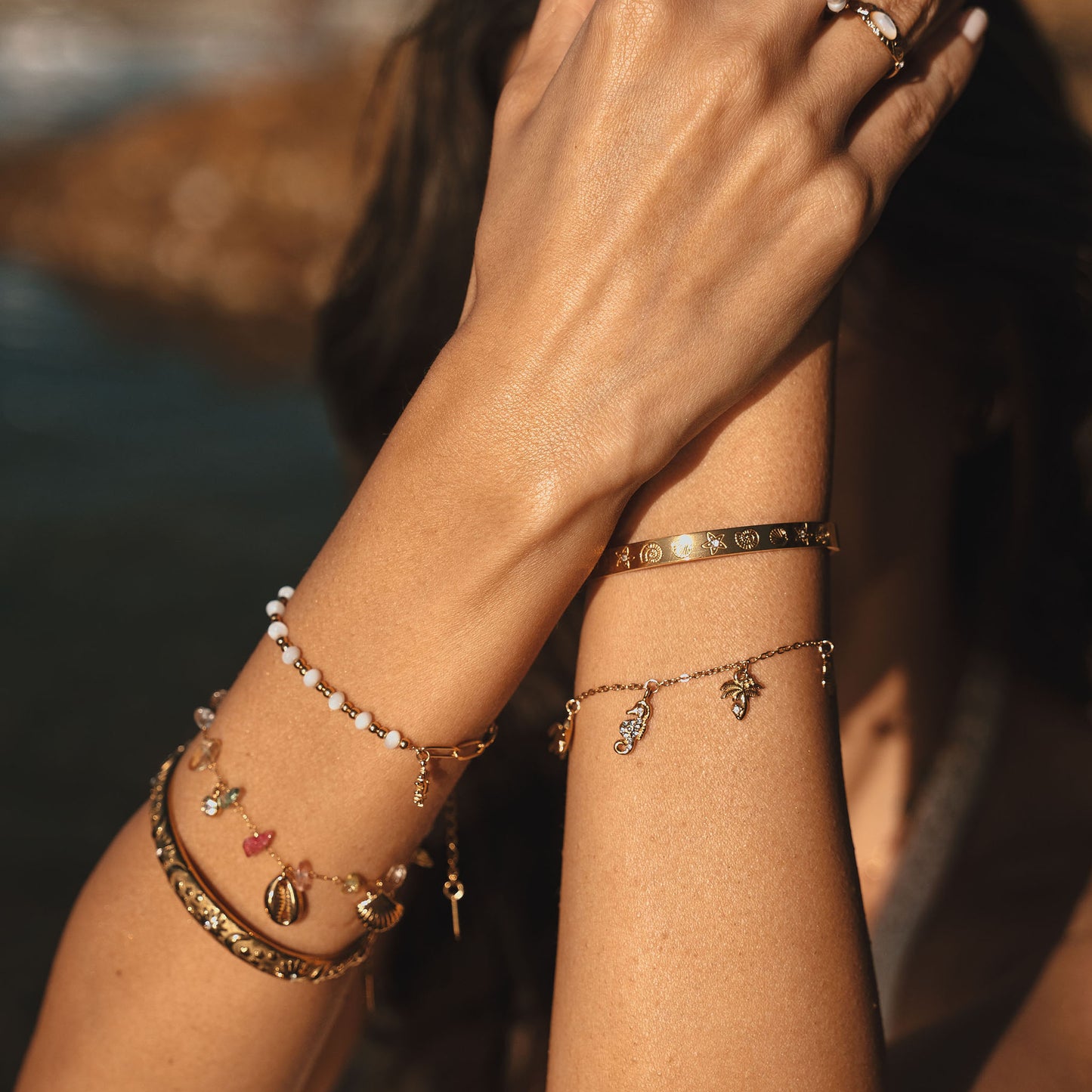 A gold bracelet featuring various ocean-themed charms against a white background. Turtle, Star, seahorse, Palm tree, shell and fish charms. Stainless steel 18k PVD Gold Plated. Waterproof jewellery. Australian jewellery. ocean inspired jewellery